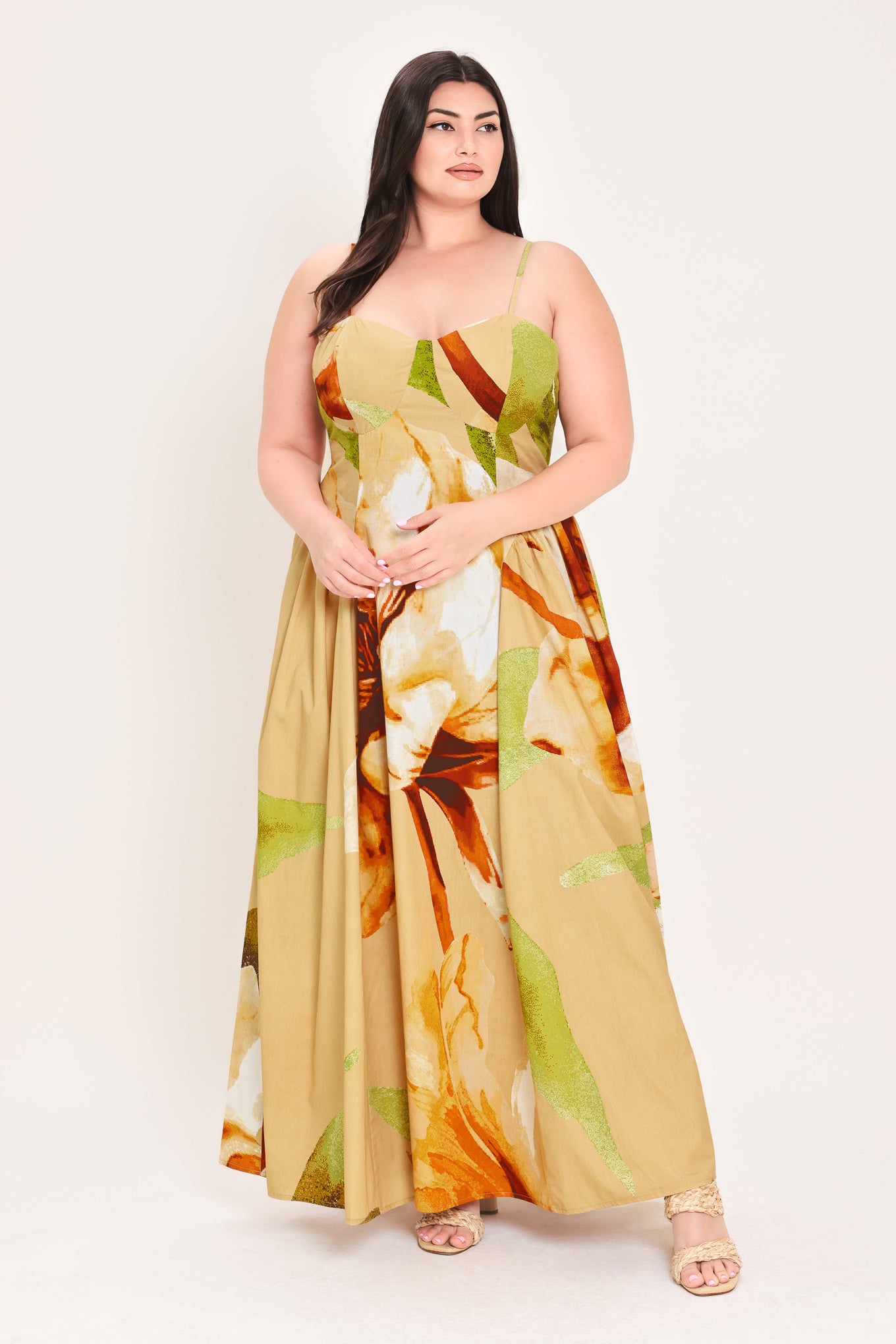 Woman wearing a green with brown and khaki floral printed maxi dress featuring bustier top, straps, side shirring detail and back zipper closure | Flying Tomato