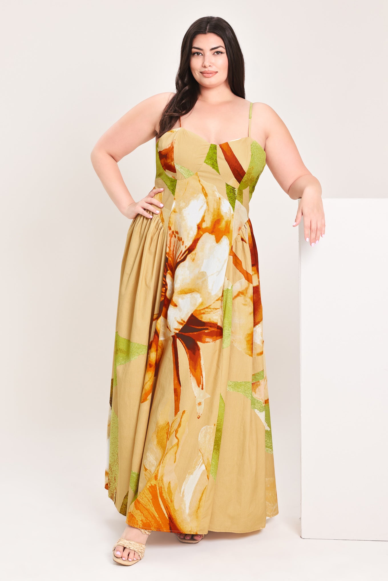 Woman wearing a green with brown and khaki floral printed maxi dress featuring bustier top, straps, side shirring detail and back zipper closure | Flying Tomato