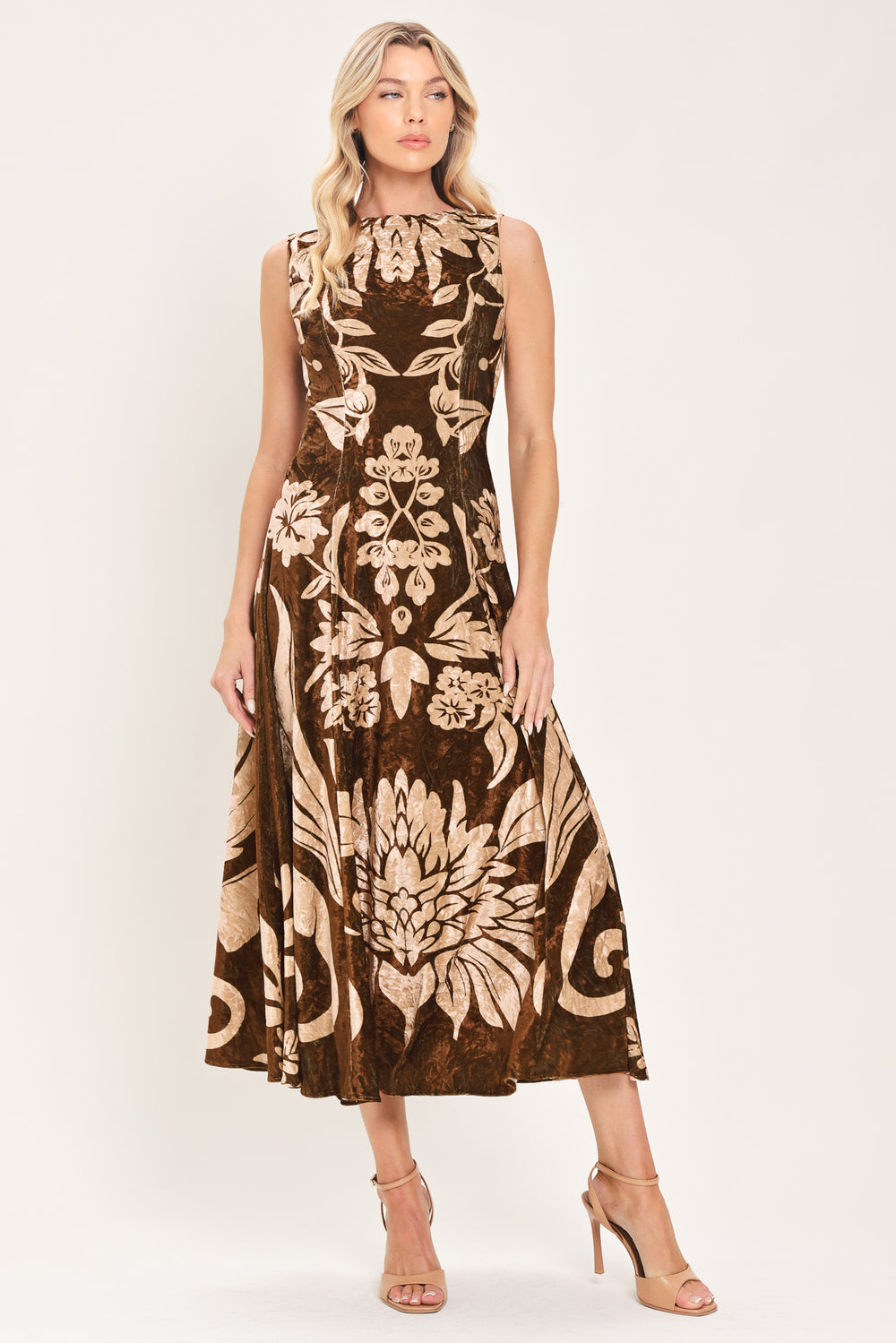 A woman modeling a sleeveless brown velvet midi dress with a large beige floral pattern | Flying Tomato