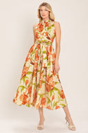 Woman wearing a sleeveless ivory and apricot floral midi dress featuring band collar, button down, self sash tie and full skirt | Flying Tomato