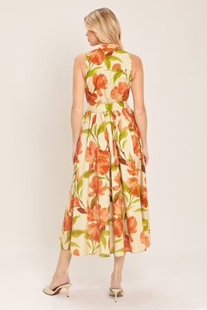 Woman wearing a sleeveless ivory and apricot floral midi dress featuring band collar, button down, self sash tie and full skirt | Flying Tomato