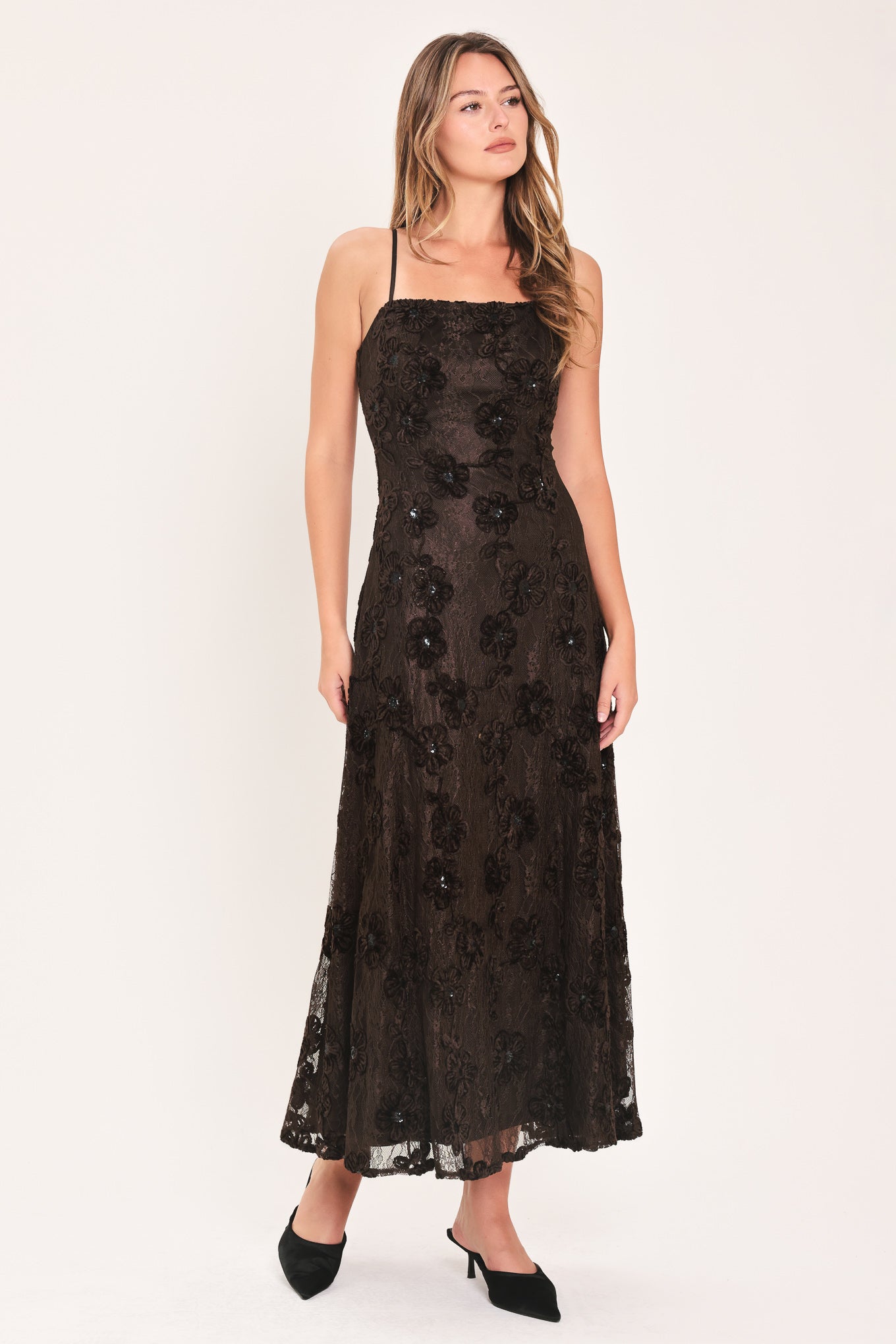 A woman modeling a brown lace midi dress with thin spaghetti straps, a fitted bodice, and a flared skirt | Flying Tomato