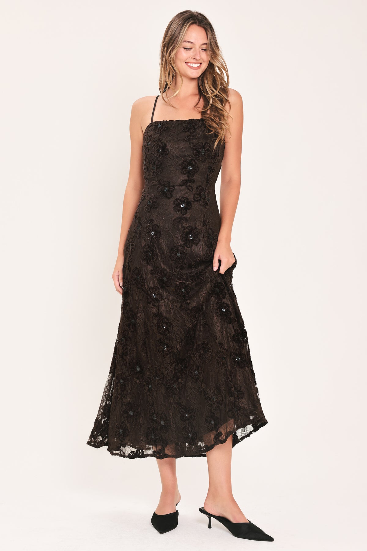 A woman modeling a brown lace midi dress with thin spaghetti straps, a fitted bodice, and a flared skirt | Flying Tomato