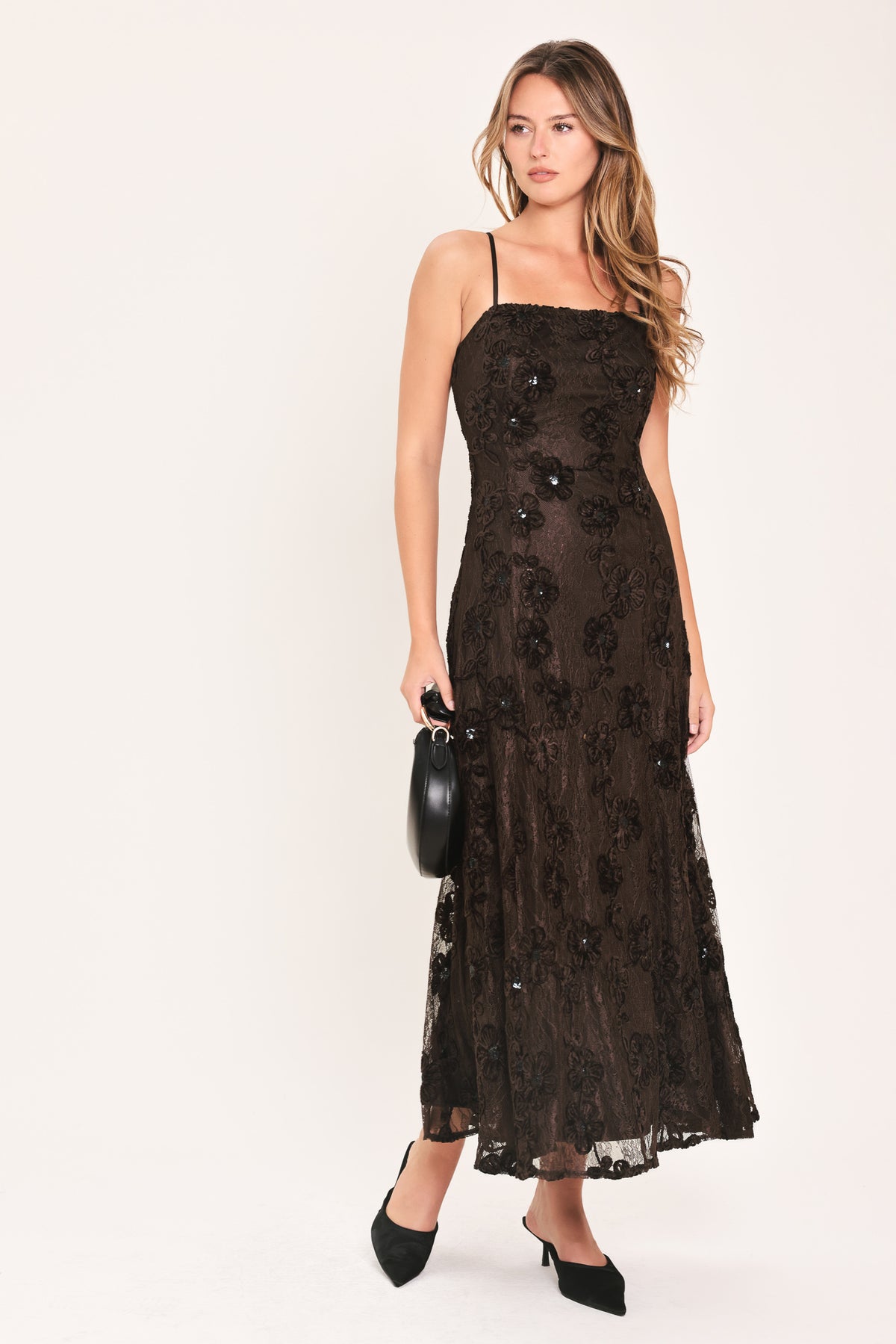 A woman modeling a brown lace midi dress with thin spaghetti straps, a fitted bodice, and a flared skirt | Flying Tomato
