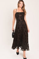 A woman modeling a brown lace midi dress with thin spaghetti straps, a fitted bodice, and a flared skirt | Flying Tomato