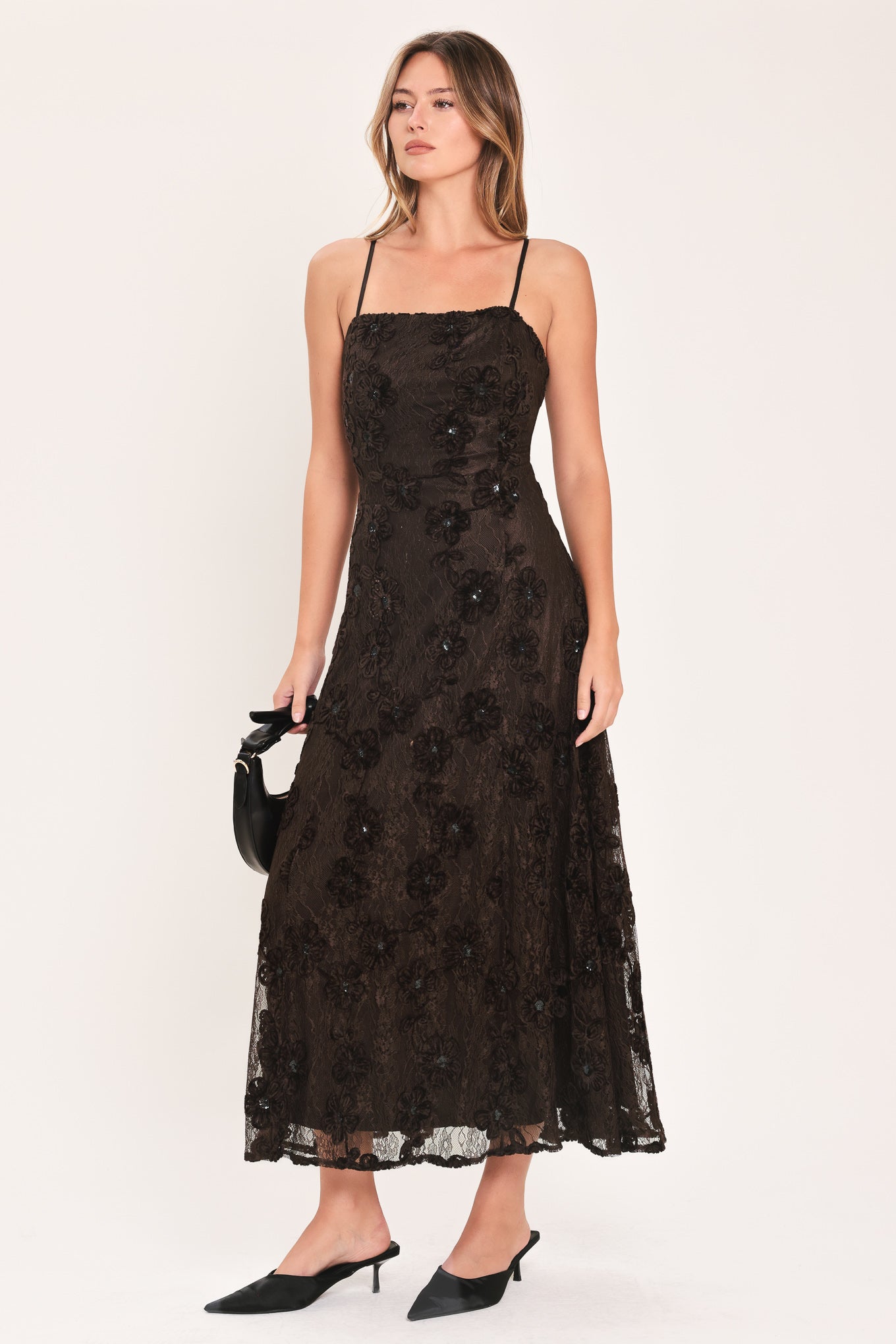A woman modeling a brown lace midi dress with thin spaghetti straps, a fitted bodice, and a flared skirt | Flying Tomato