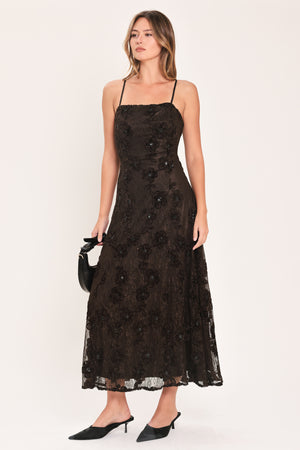 A woman modeling a brown lace midi dress with thin spaghetti straps, a fitted bodice, and a flared skirt | Flying Tomato