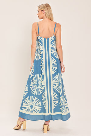 Woman wearing a blue and white patterned maxi dress featuring straight neckline, straps and bare back with zipper closure | Flying Tomato