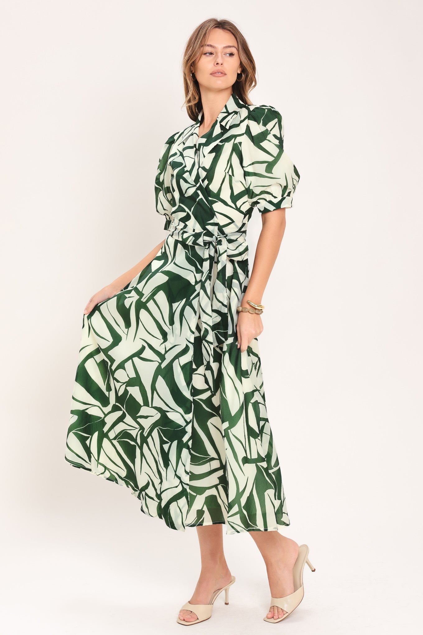 Woman wearing an green and ivory leaf-patterned true wrap midi dress featuring collar, puff short sleeve and full skirt | Flying Tomato