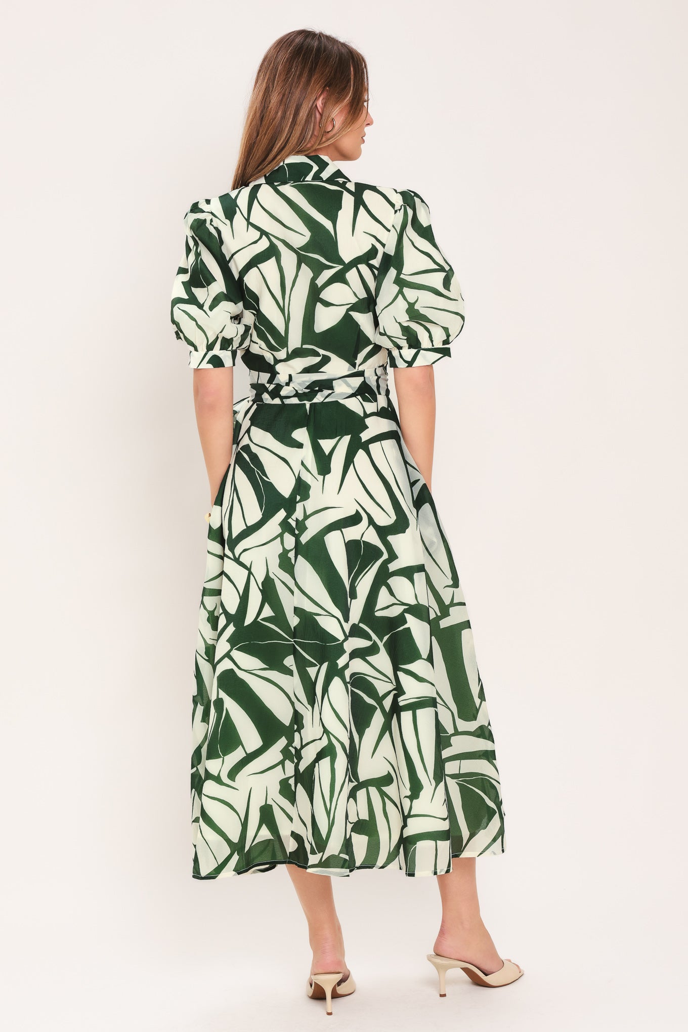 Woman wearing an green and ivory leaf-patterned true wrap midi dress featuring collar, puff short sleeve and full skirt | Flying Tomato