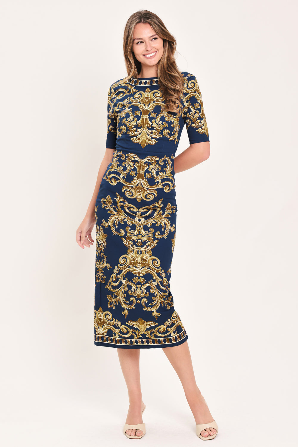 A woman wearing a navy blue midi dress with an ornate gold baroque pattern, featuring short sleeves and a crew neck | Flying Tomato