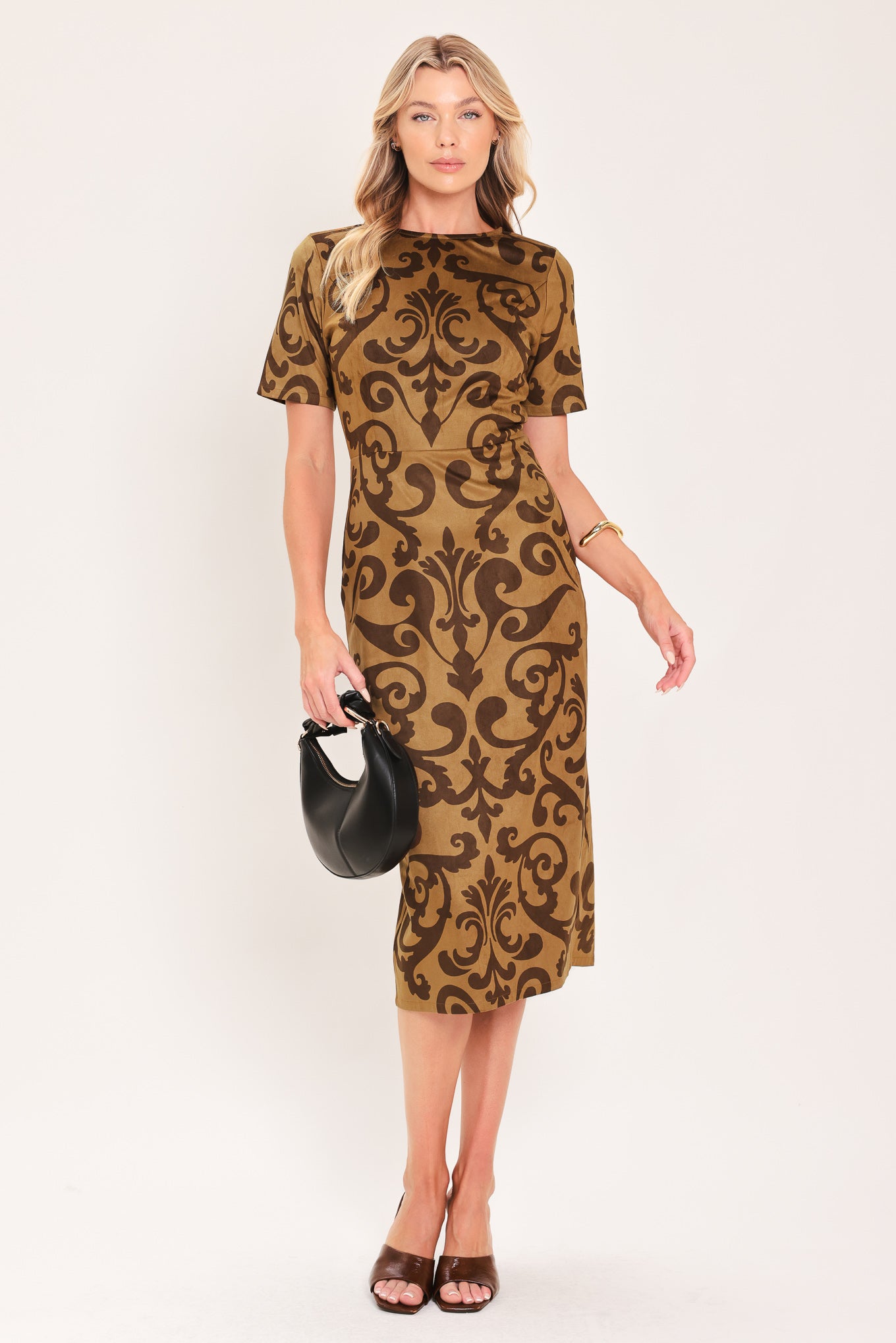A woman modeling a short-sleeve faux suede camel midi dress with a brown damask pattern | Flying Tomato