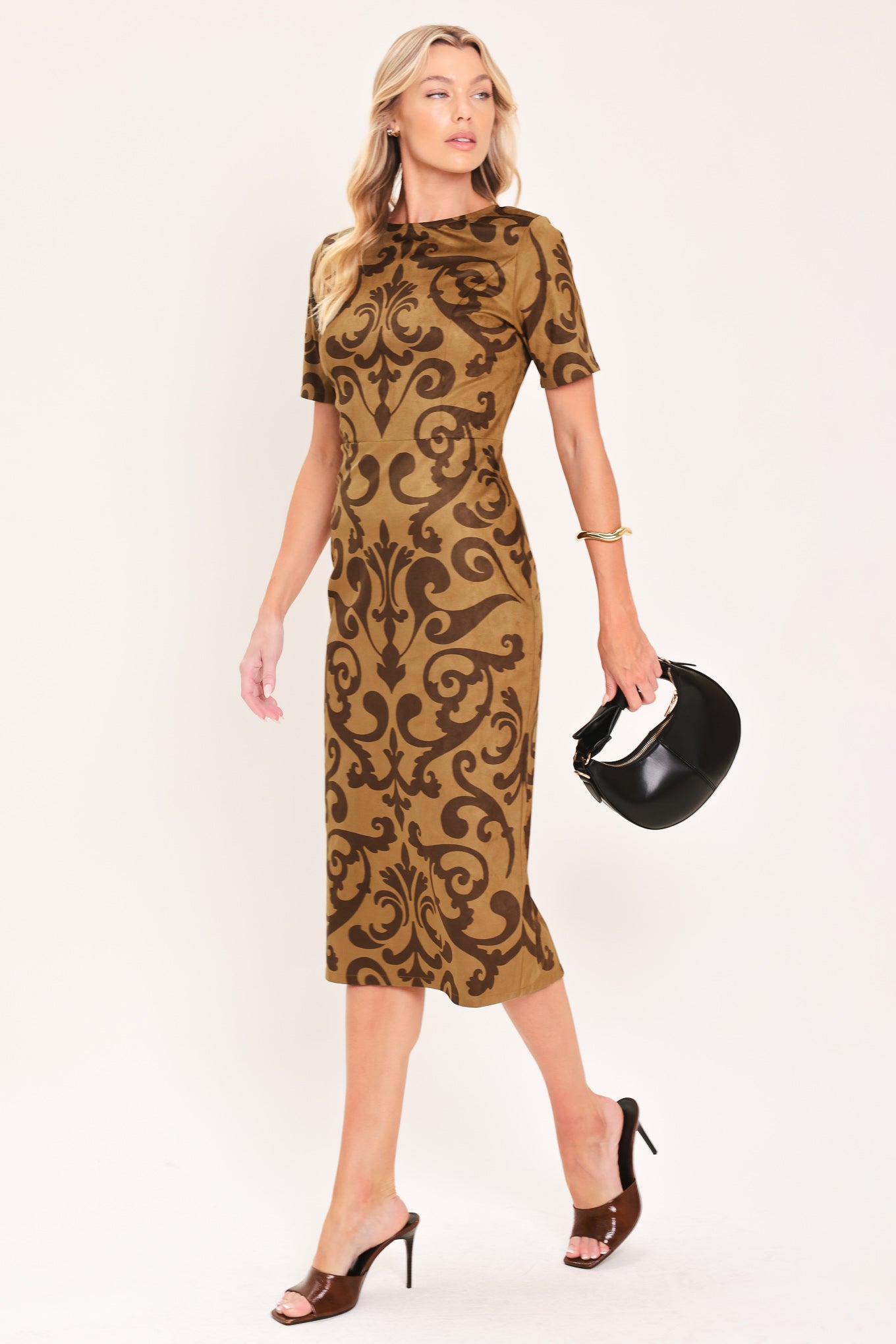 A woman modeling a short-sleeve faux suede camel midi dress with a brown damask pattern | Flying Tomato