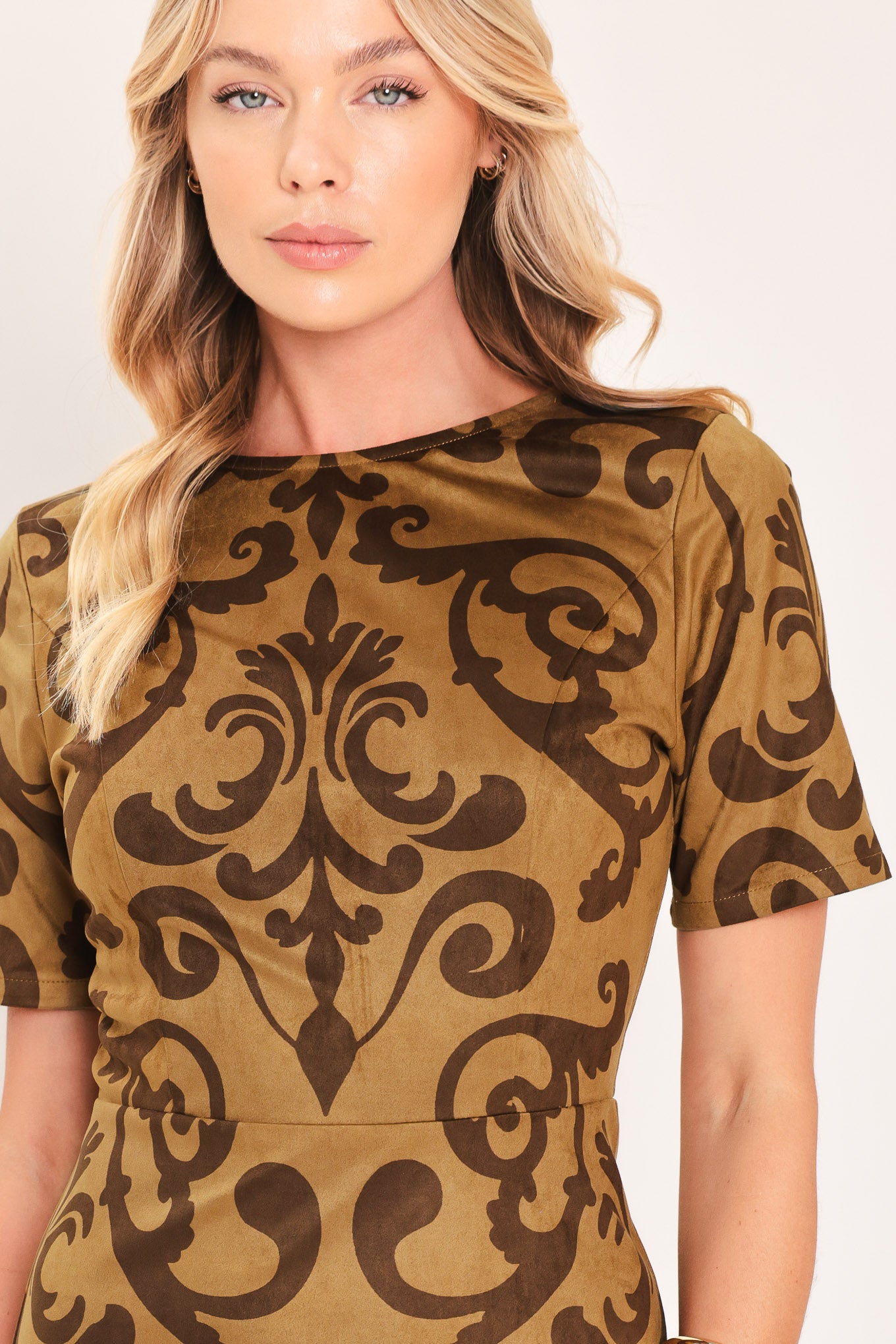 A woman modeling a short-sleeve faux suede camel midi dress with a brown damask pattern | Flying Tomato