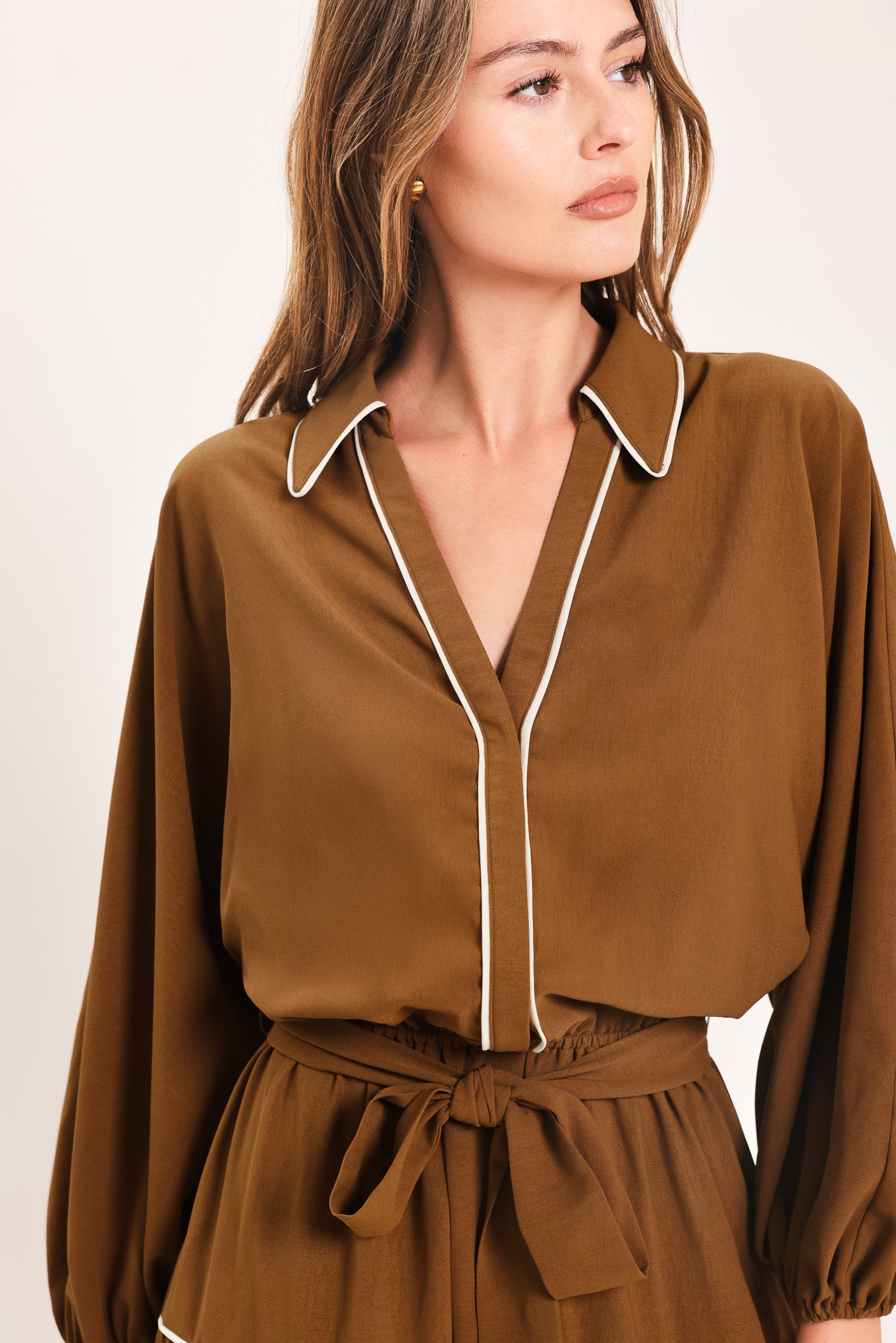 A woman wearing a brown long sleeve midi dress with white lined details, tiered skirt and self tie belt | Flying Tomato