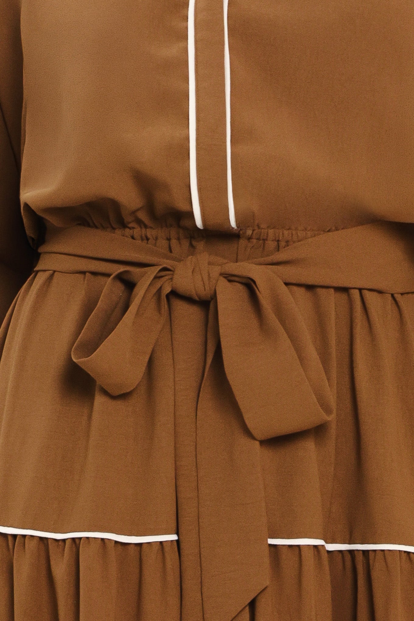 A woman wearing a brown long sleeve midi dress with white lined details, tiered skirt and self tie belt | Flying Tomato