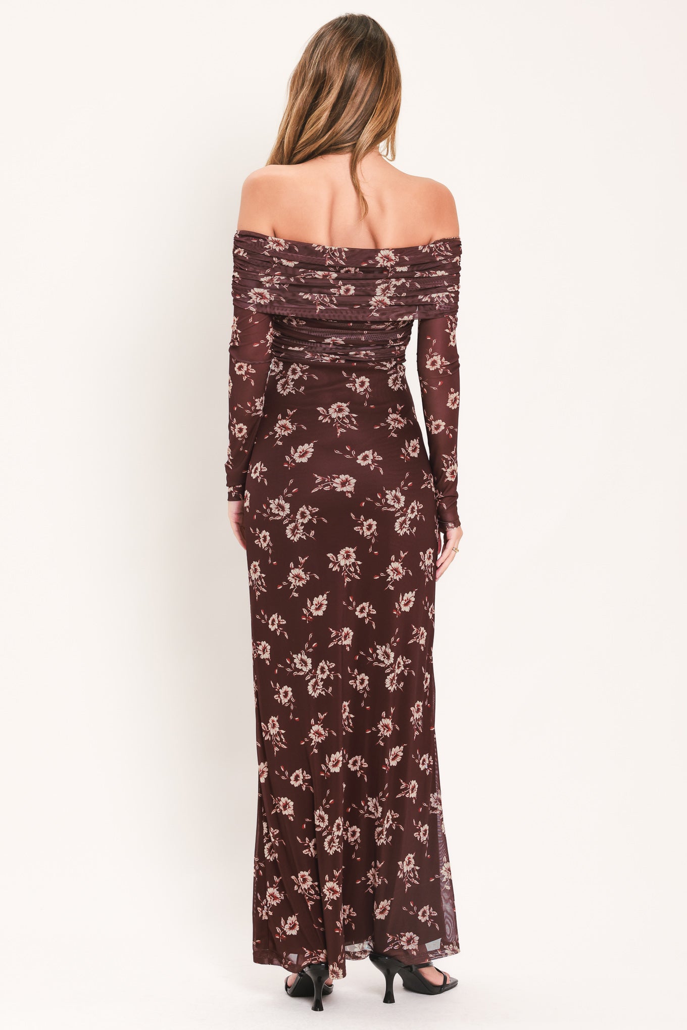 A woman modeling an off-the-shoulder long-sleeve maxi dress with a dark brown base and a beige floral pattern | Flying Tomato