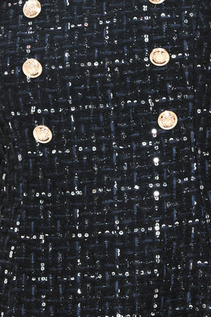 A woman modeling a sleeveless navy blue tweed mini dress with a square neckline, wide shoulder straps, and double-breasted gold buttons | Flying Tomato