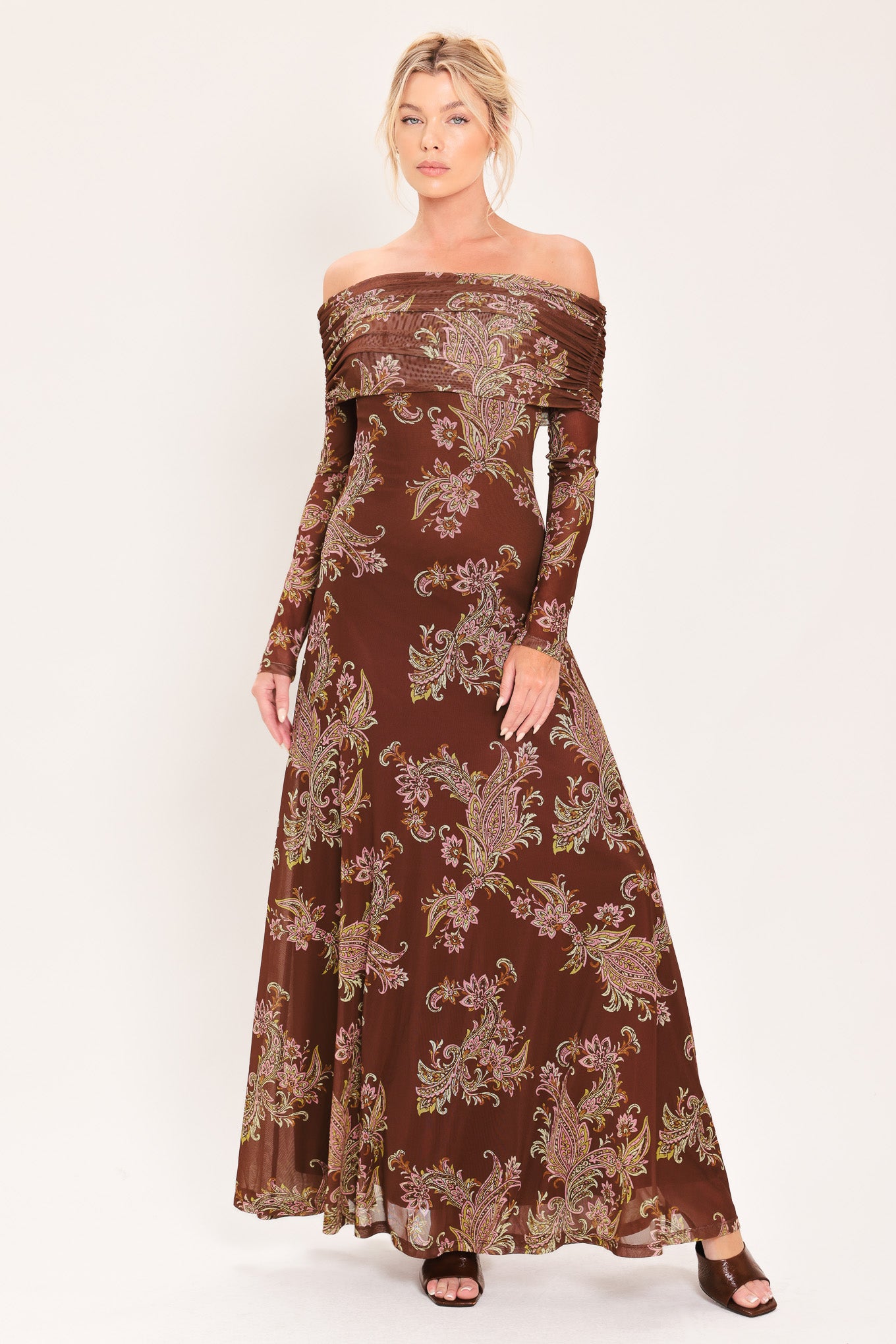 An off-the-shoulder long-sleeve maxi dress in dark brown with an intricate paisley and floral pattern in beige, gold, and muted green | Flying Tomato