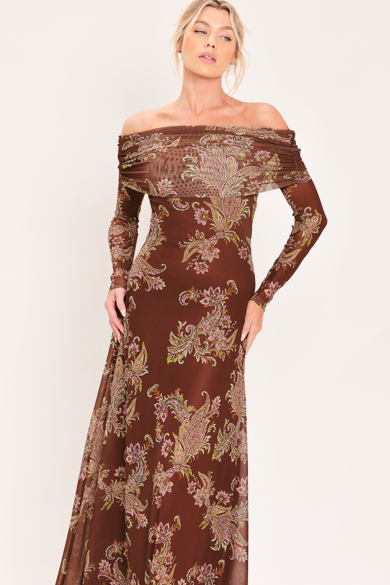 An off-the-shoulder long-sleeve maxi dress in dark brown with an intricate paisley and floral pattern in beige, gold, and muted green | Flying Tomato