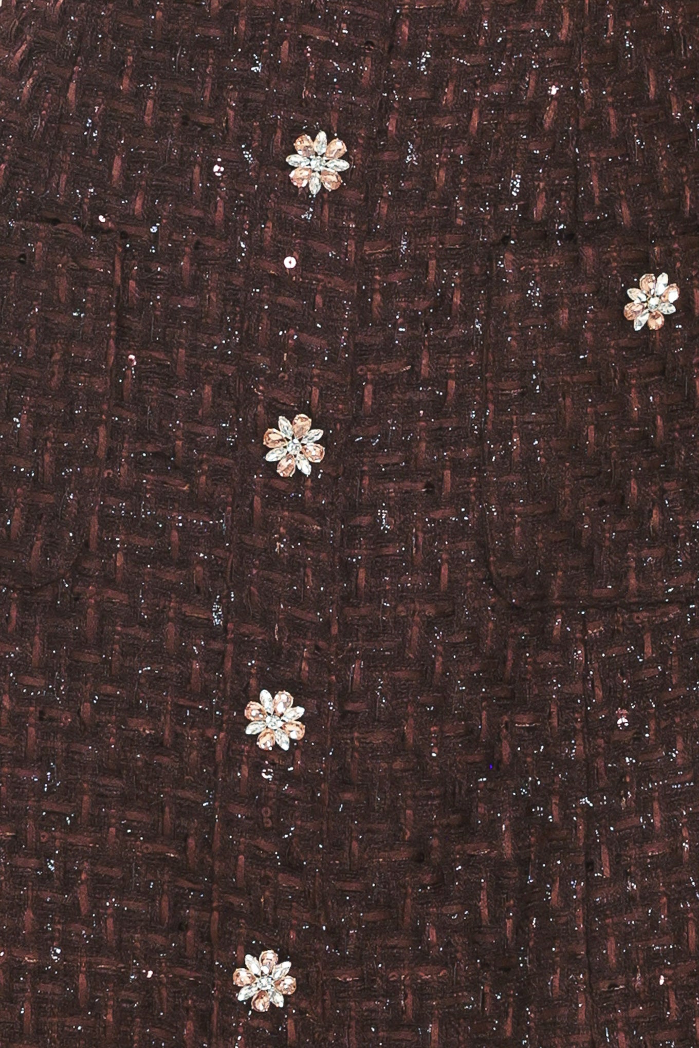 A woman modeling a sleeveless brown tweed mini dress with decorative silver floral embellishments down the front | Flying Tomato