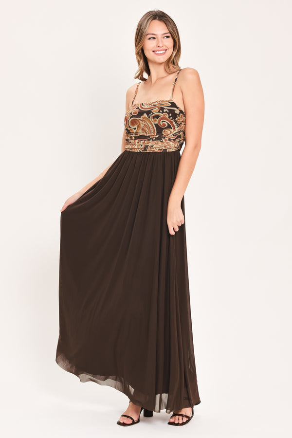 A woman modeling a long brown maxi dress with a patterned bodice and flowing power mesh skirt | Flying Tomato