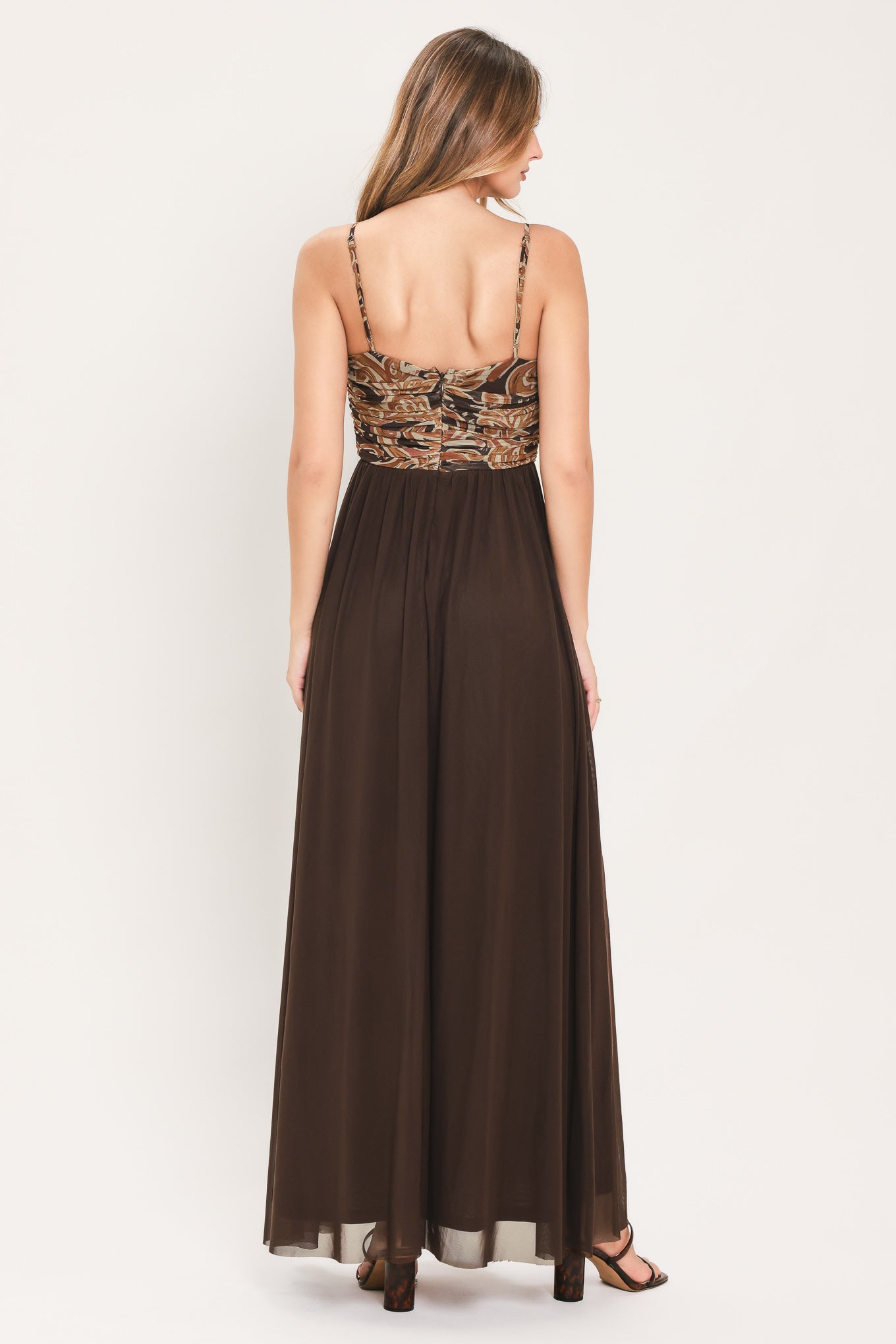 A woman modeling a long brown maxi dress with a patterned bodice and flowing power mesh skirt | Flying Tomato