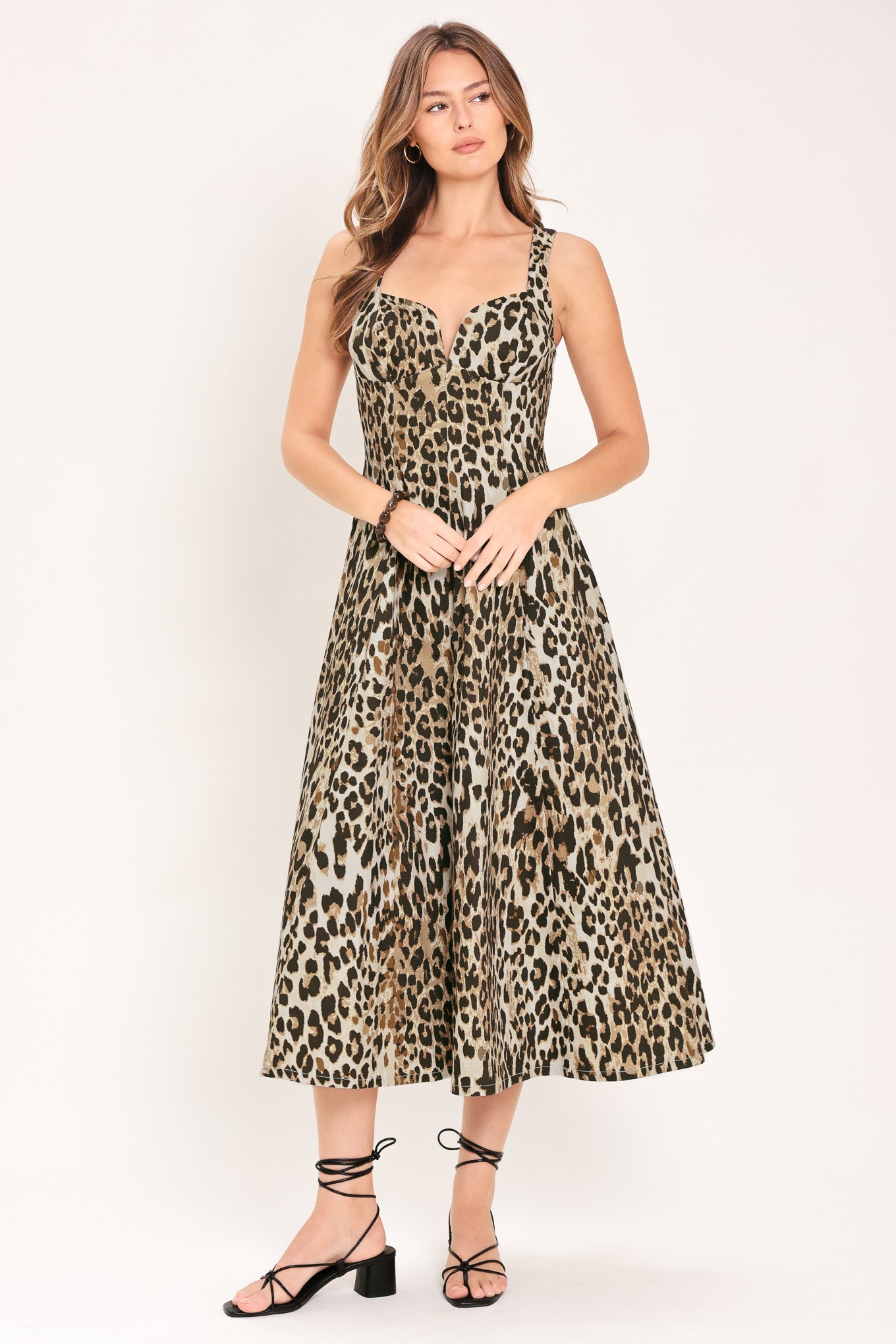 Woman wearing a sleeveless leopard print midi dress featuring sweetheart neckline, circle skirt and back zipper closure | Flying Tomato