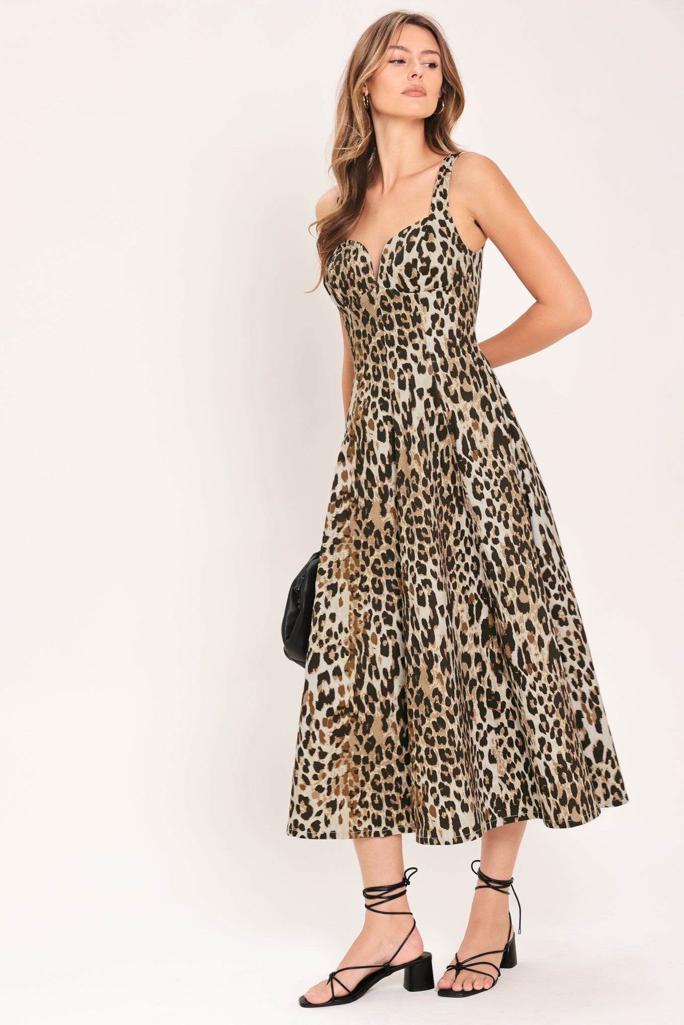 Woman wearing a sleeveless leopard print midi dress featuring sweetheart neckline, circle skirt and back zipper closure | Flying Tomato