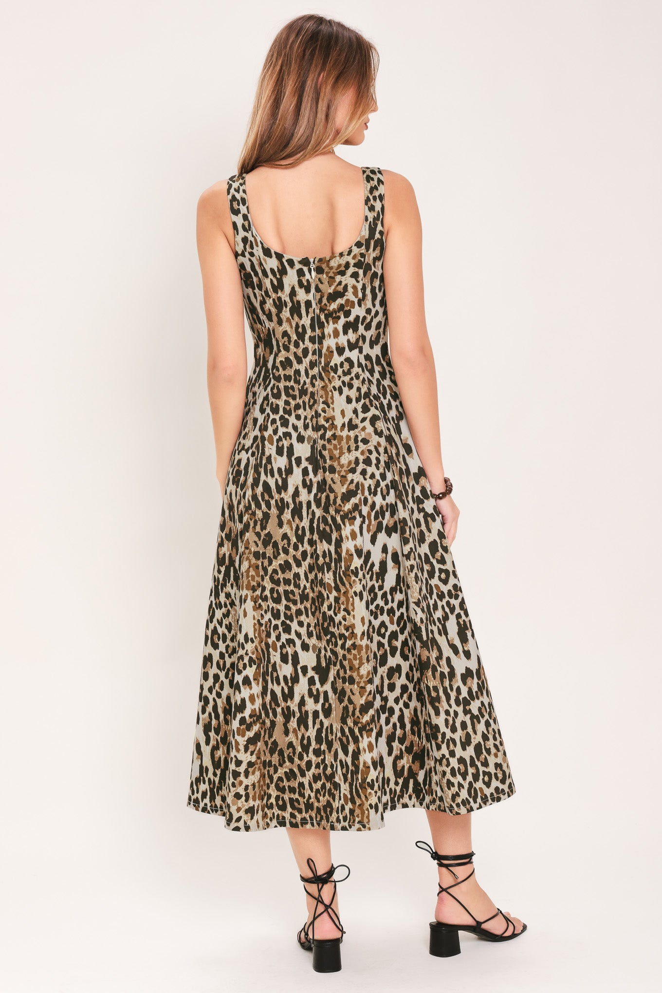 Woman wearing a sleeveless leopard print midi dress featuring sweetheart neckline, circle skirt and back zipper closure | Flying Tomato