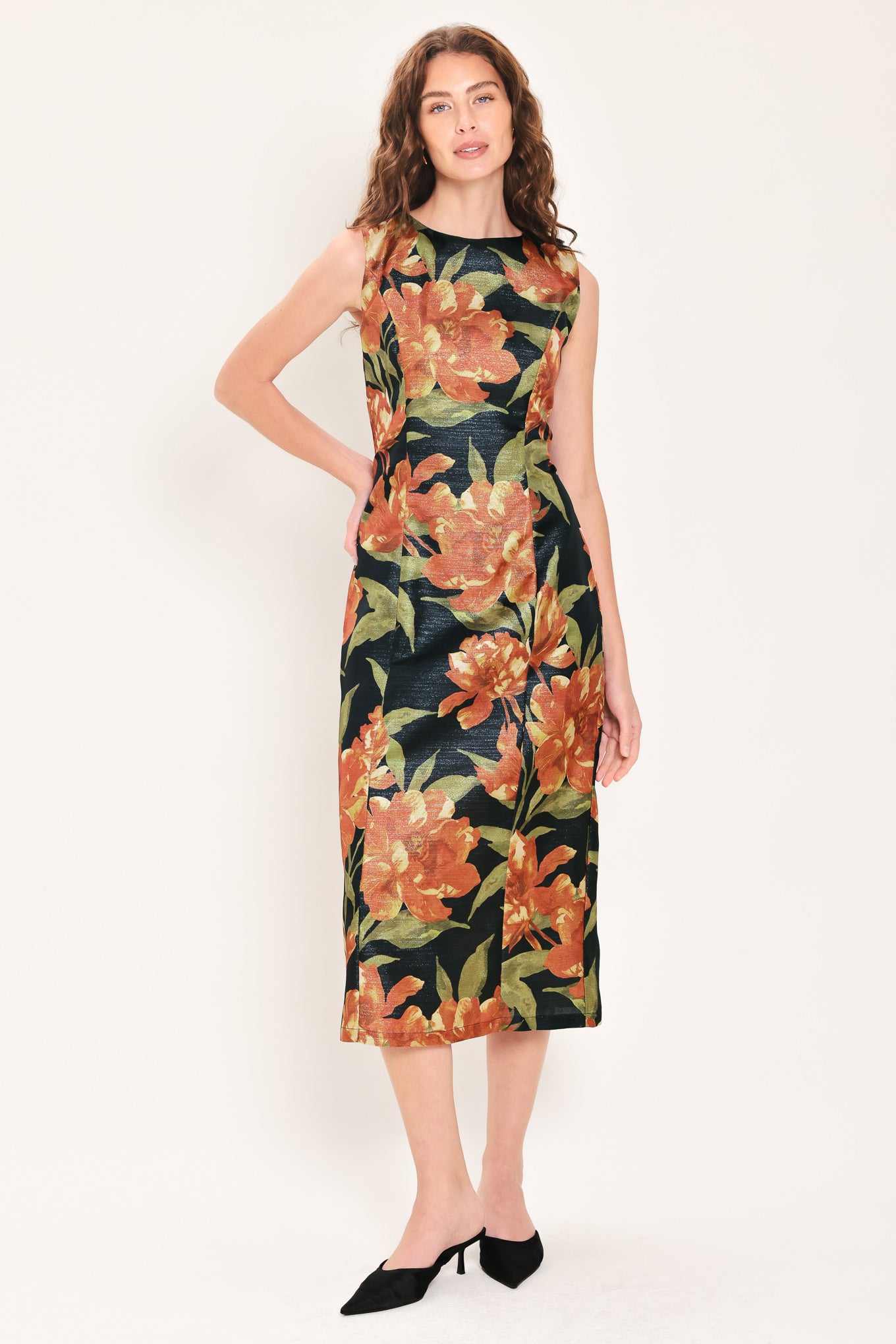 Woman wearing a sleeveless black midi sheath dress with orange flowers and green leaves printed | Flying Tomato