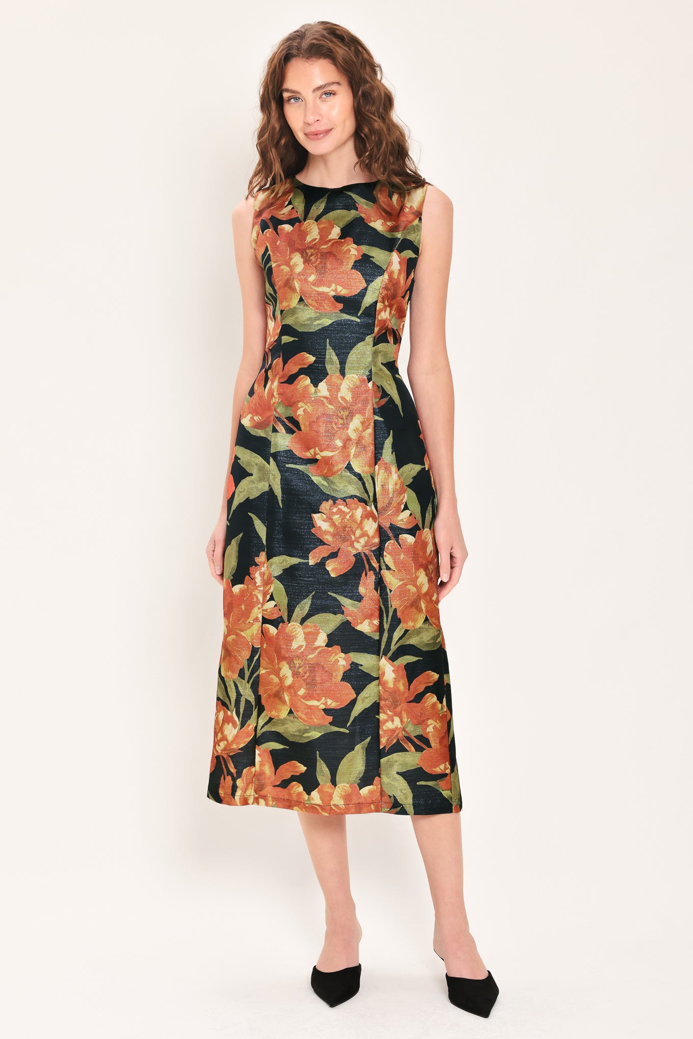 Woman wearing a sleeveless black midi sheath dress with orange flowers and green leaves printed | Flying Tomato