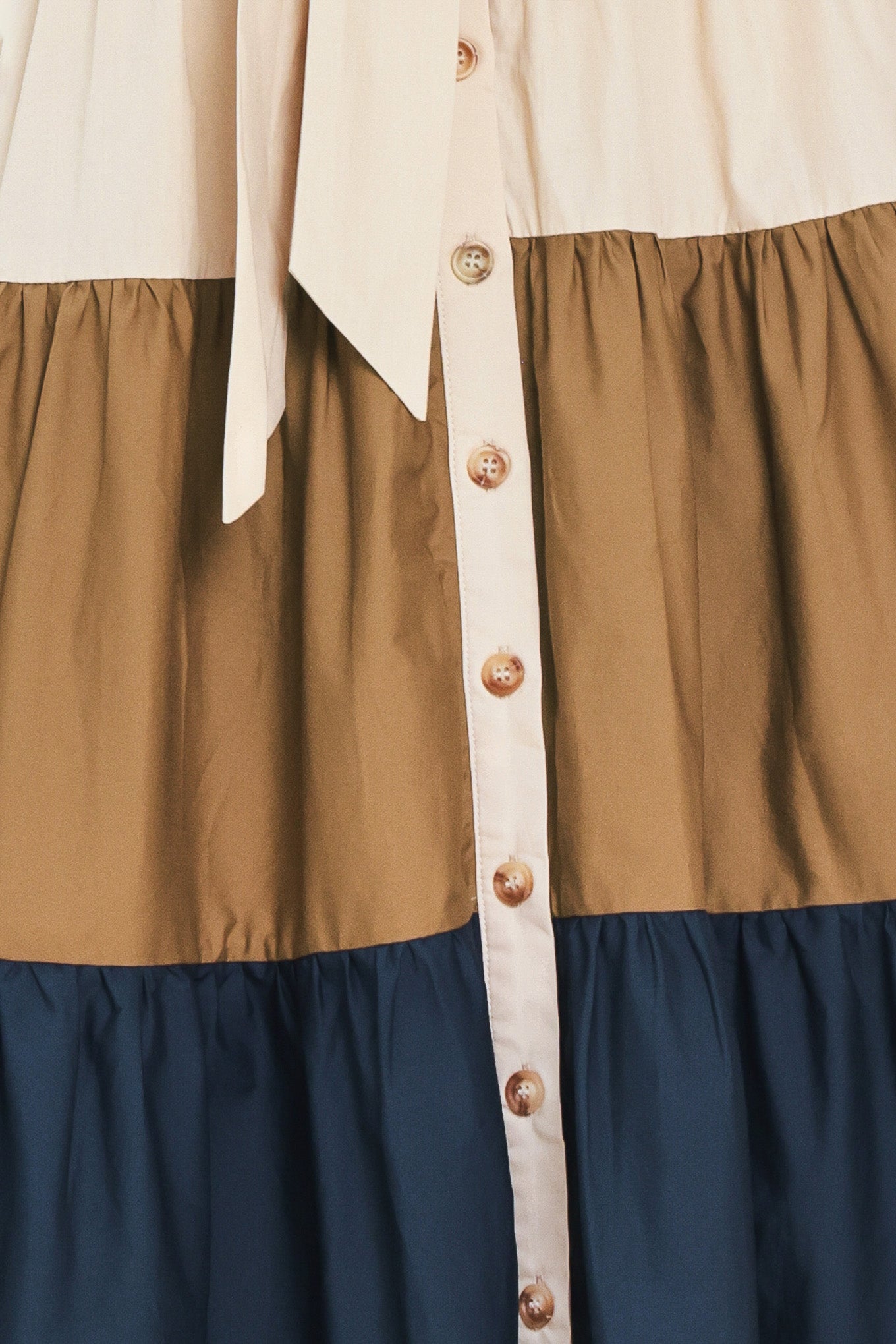 Woman wearing a color-blocked midi dress with beige, brown, and navy | Flying Tomato