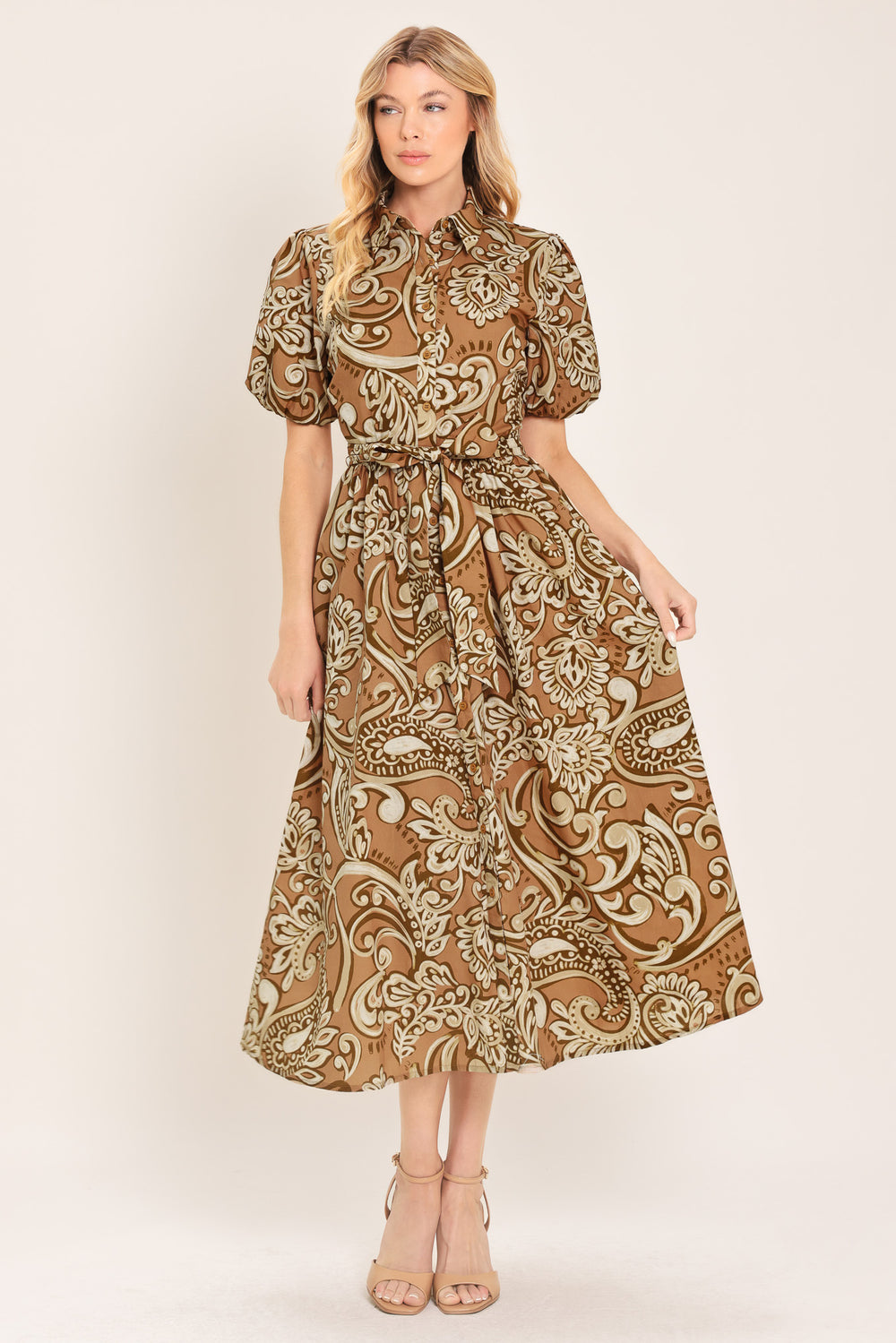 Woman wearing a patterned taupe and brown midi dress featuring collar, short puff sleeve, front button down, self sash and full skirt | Flying Tomato