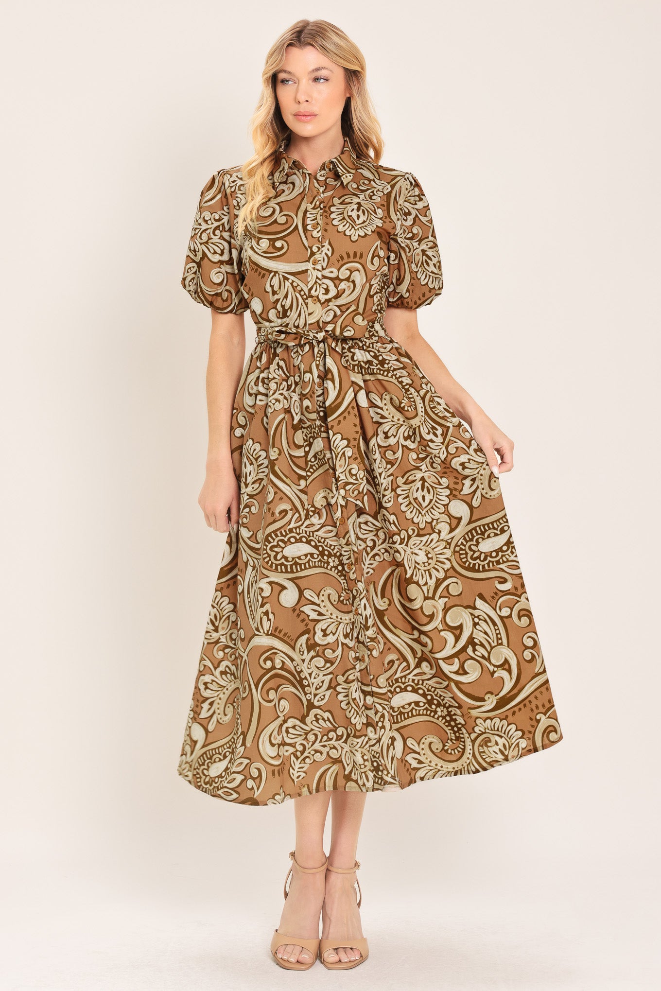 Woman wearing a patterned taupe and brown midi dress featuring collar, short puff sleeve, front button down, self sash and full skirt | Flying Tomato