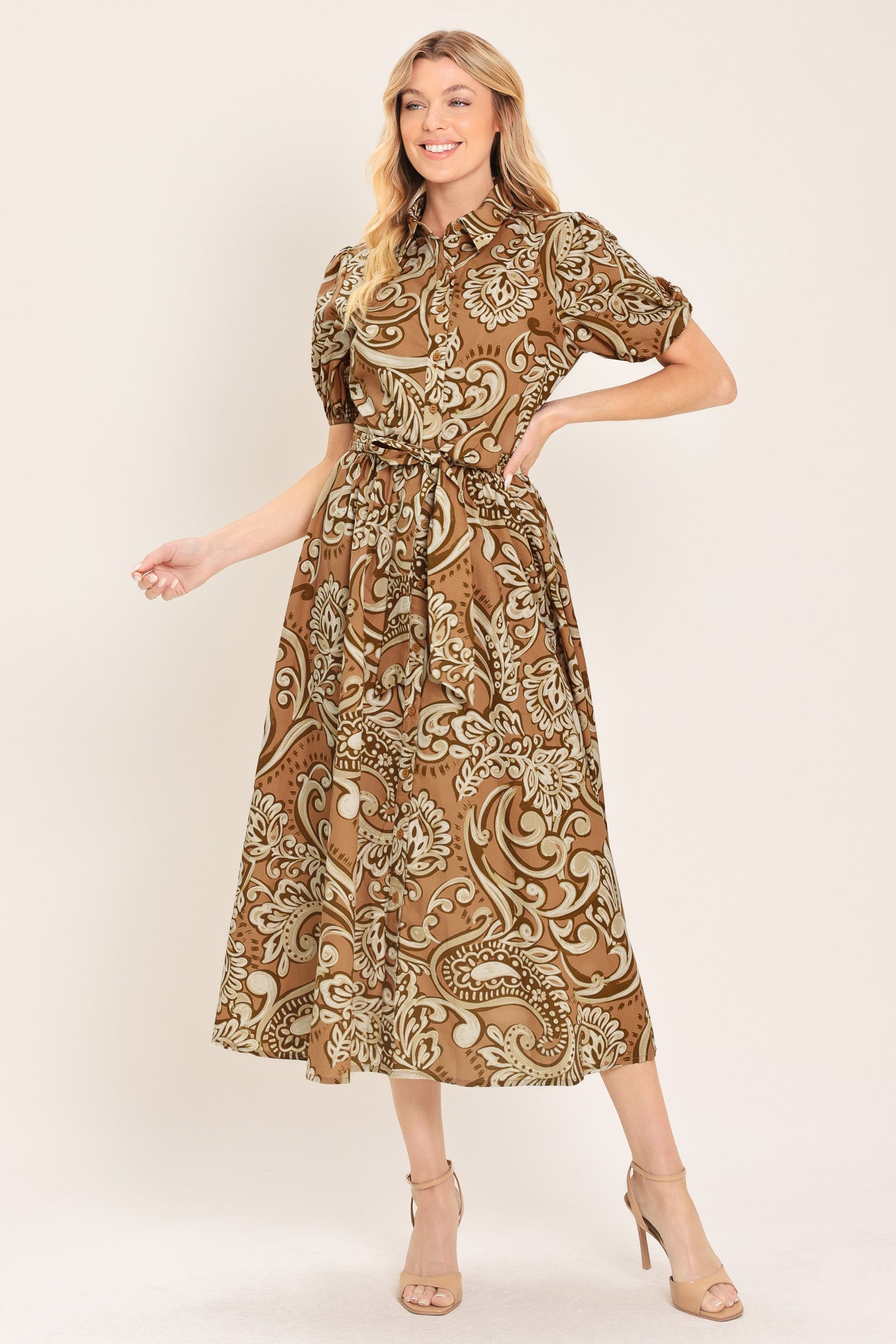 Woman wearing a patterned taupe and brown midi dress featuring collar, short puff sleeve, front button down, self sash and full skirt | Flying Tomato