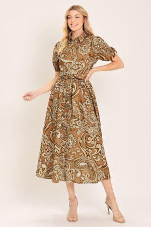Woman wearing a patterned taupe and brown midi dress featuring collar, short puff sleeve, front button down, self sash and full skirt | Flying Tomato