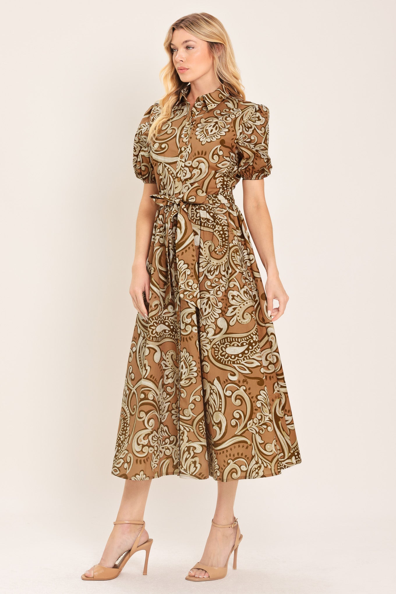 Woman wearing a patterned taupe and brown midi dress featuring collar, short puff sleeve, front button down, self sash and full skirt | Flying Tomato