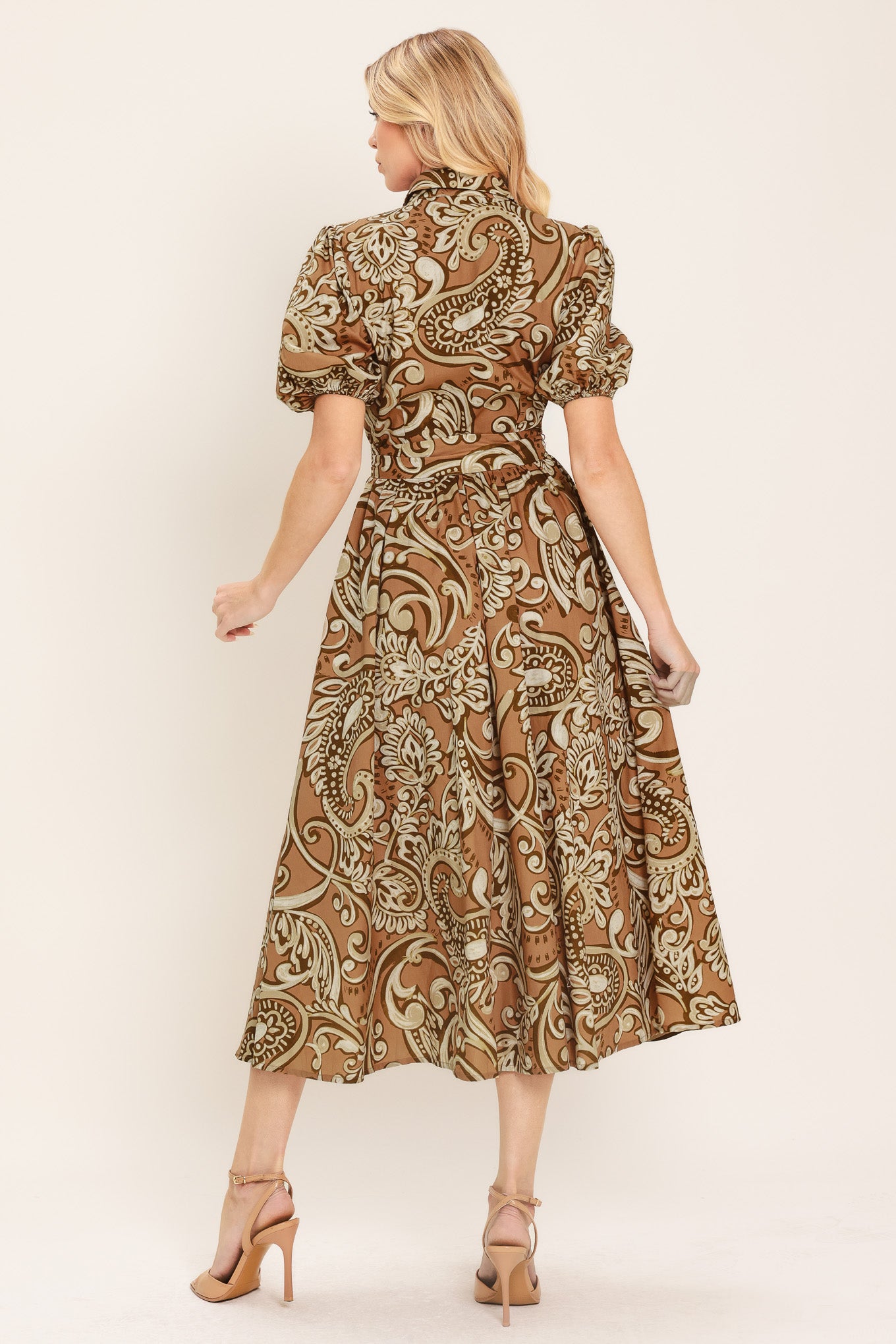 Woman wearing a patterned taupe and brown midi dress featuring collar, short puff sleeve, front button down, self sash and full skirt | Flying Tomato