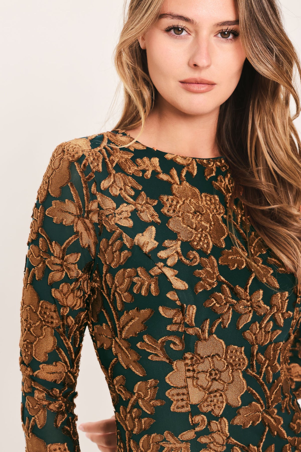 A woman modeling a long-sleeve midi dress with a brown and dark green floral pattern | FLying Tomato