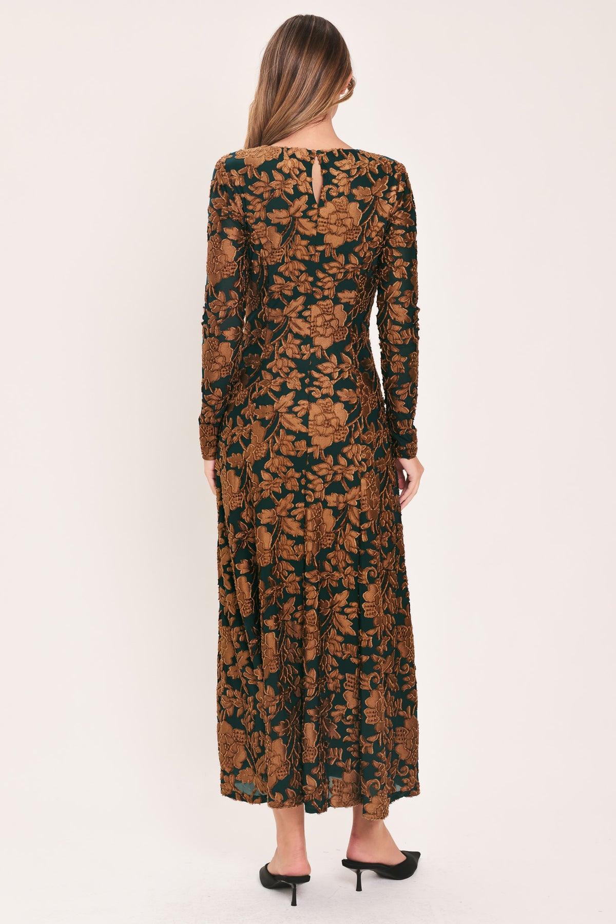 A woman modeling a long-sleeve midi dress with a brown and dark green floral pattern | FLying Tomato