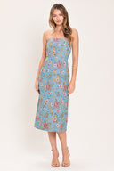 A woman models a strapless midi dress with a light blue base and a colorful floral pattern | Flying Tomato