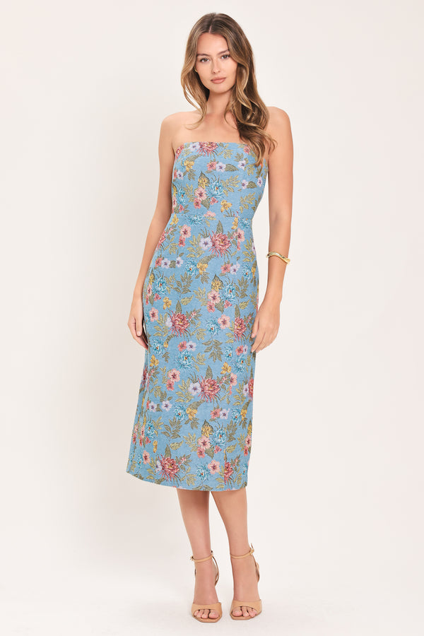 A woman models a strapless midi dress with a light blue base and a colorful floral pattern | Flying Tomato