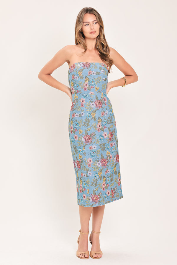 A woman models a strapless midi dress with a light blue base and a colorful floral pattern | Flying Tomato