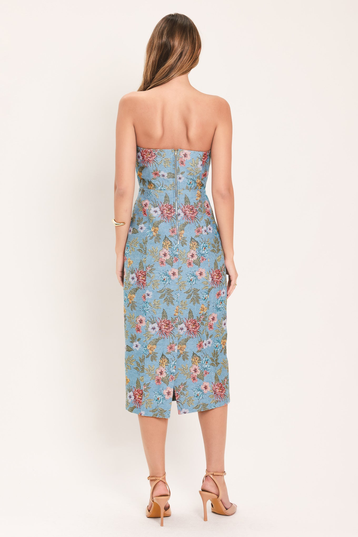 A woman models a strapless midi dress with a light blue base and a colorful floral pattern | Flying Tomato