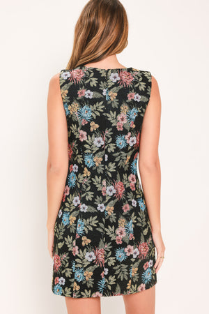 A woman modeling a sleeveless black mini dress with a colorful floral print | Flying Tomato