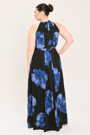 A woman modeling a sleeveless halter-neck maxi dress with a black base and a large blue floral print | Plus Curve Flying Tomato