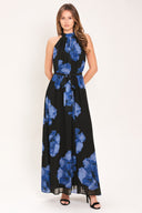 Woman wearing a black maxi dress with blue floral pattern, back neck button closure, and self sash tie | Flying Tomato