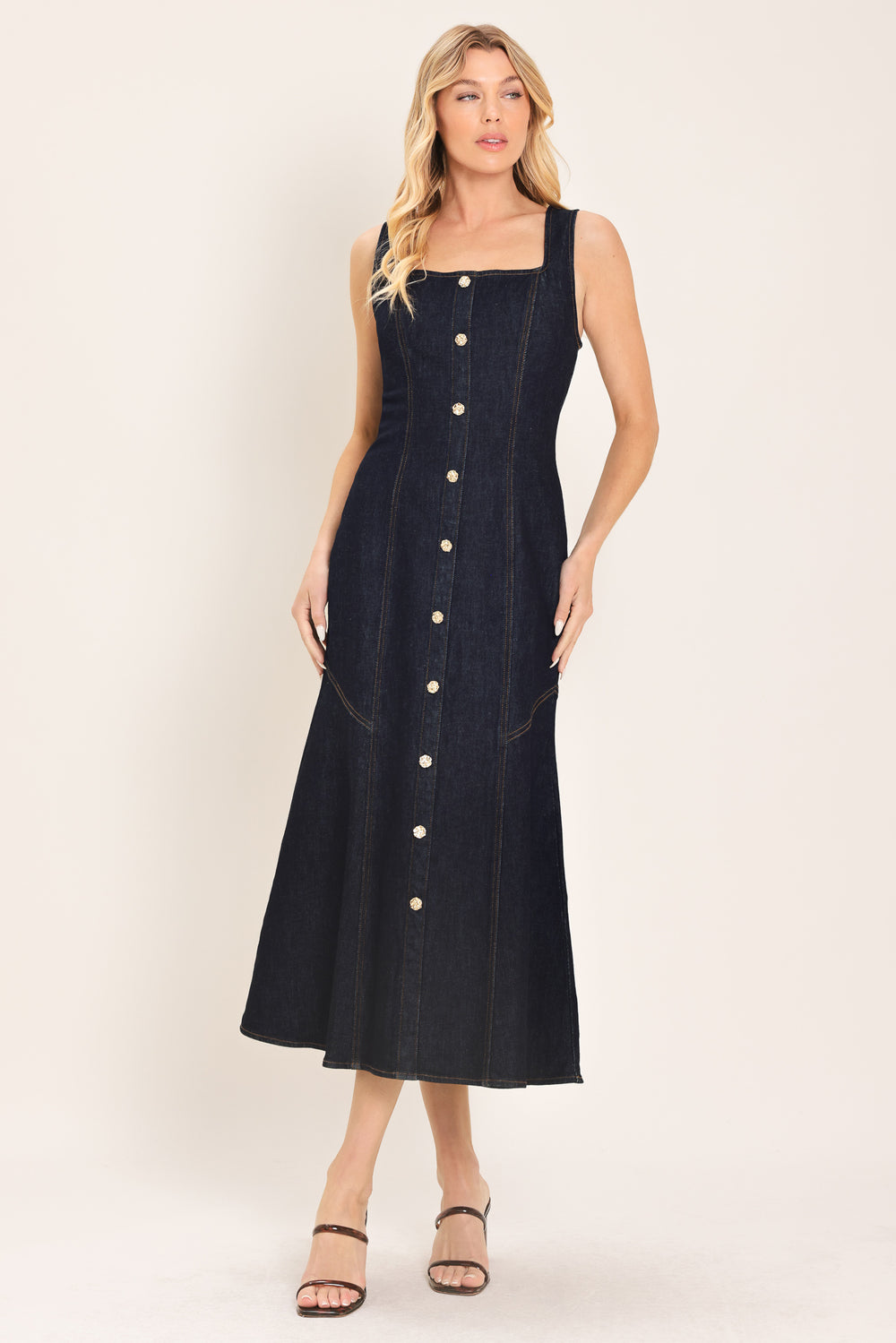 Woman wearing a dark indigo denim sleeveless midi dress with buttons | Flying Tomato