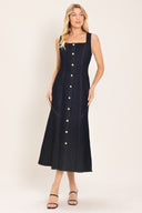 Woman wearing a dark indigo denim sleeveless midi dress with buttons | Flying Tomato